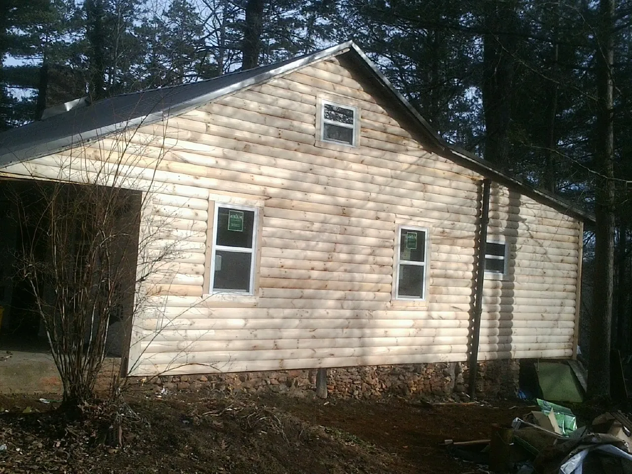New log siding and dark metal roofing on a gable end in Windsor